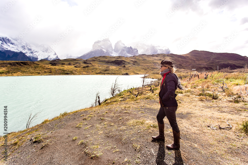 Fototapeta premium woman looking toward awesome view of Torres del Paine mountain range