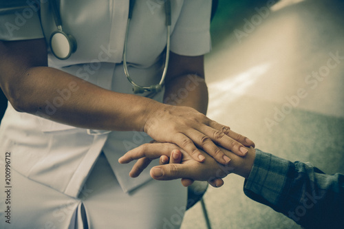 Nurse holding the hand of a patient man, showing sympathy and kindness, vintage style