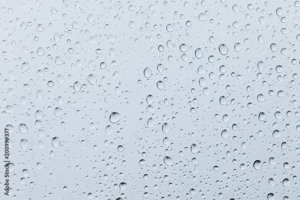 Drops of rain on a window glass. Through the window view of overcast clouds Drops of rain on a window glass. Through the window view of overcast clouds