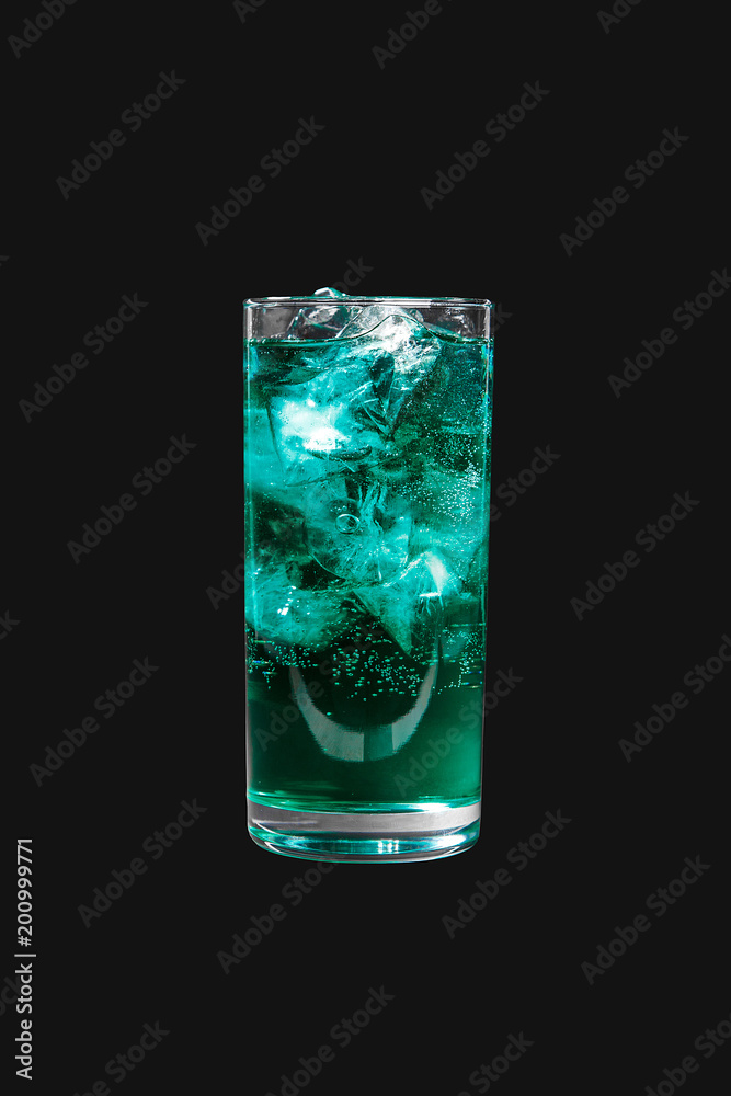 Single-colored transparent cocktail, blue, blue refreshing carbonated in a high glass with ice cubes. Side view. Isolated black background. Drink for the menu restaurant, bar, cafe Single-colored transparent cocktail, blue, blue refreshing carbonated in a high glass with ice cubes. Side view. Isolated black background. Drink for the menu restaurant, bar, cafe
