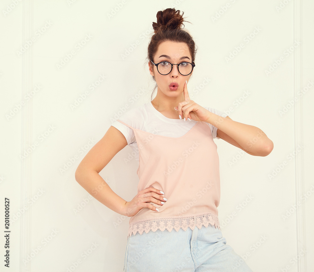 Portrait of young beautiful brunette woman girl model with nude makeup in colorful summer pink hipster clothes posing near wall. Have and idea Portrait of young beautiful brunette woman girl model with nude makeup in colorful summer pink hipster clothes posing near wall. Have and idea