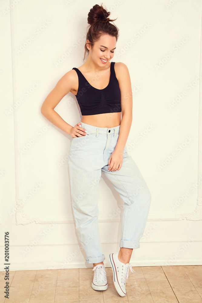 Portrait of young beautiful brunette woman girl model with nude makeup in summer T-shirt top and jeans hipster clothes posing near wall. Going crazy Portrait of young beautiful brunette woman girl model with nude makeup in summer T-shirt top and jeans hipster clothes posing near wall. Going crazy