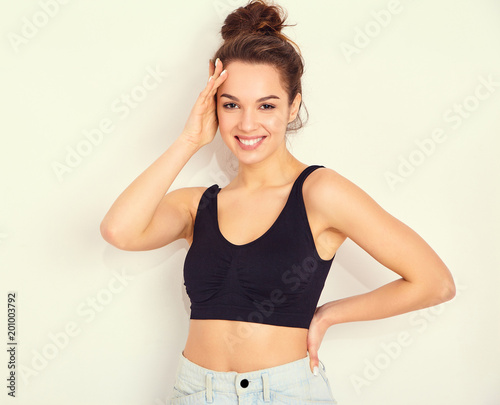 Portrait of young beautiful brunette woman girl model with nude makeup in summer T-shirt top and jeans hipster clothes posing near wall. Going crazy
