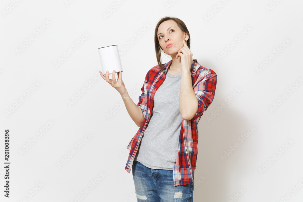 Young pensive beautiful woman holding empty paint tin can with copy space on camera isolated on white background. Instruments, accessories, tools for renovation apartment room. Repair home concept.