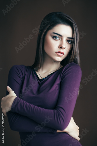 Sexy beautiful young woman in dress posing on dark background