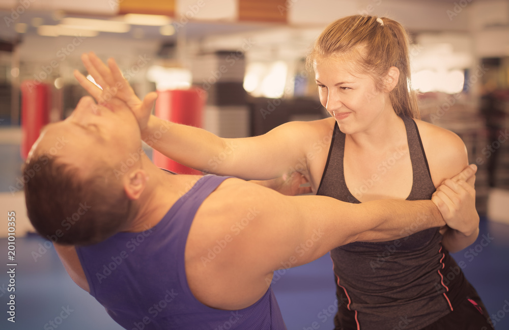 Young woman is fighting with trainer