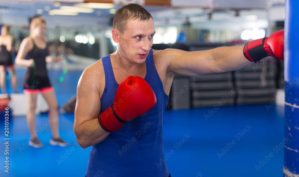 Positive male is fighting punching bag