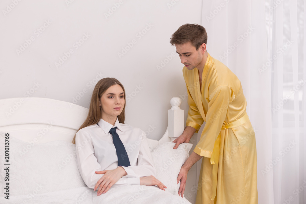 Relax sweetie. Malleable loving boyfriend wearing a bathrobe and making his  woman comfortable in bed Stock Photo | Adobe Stock