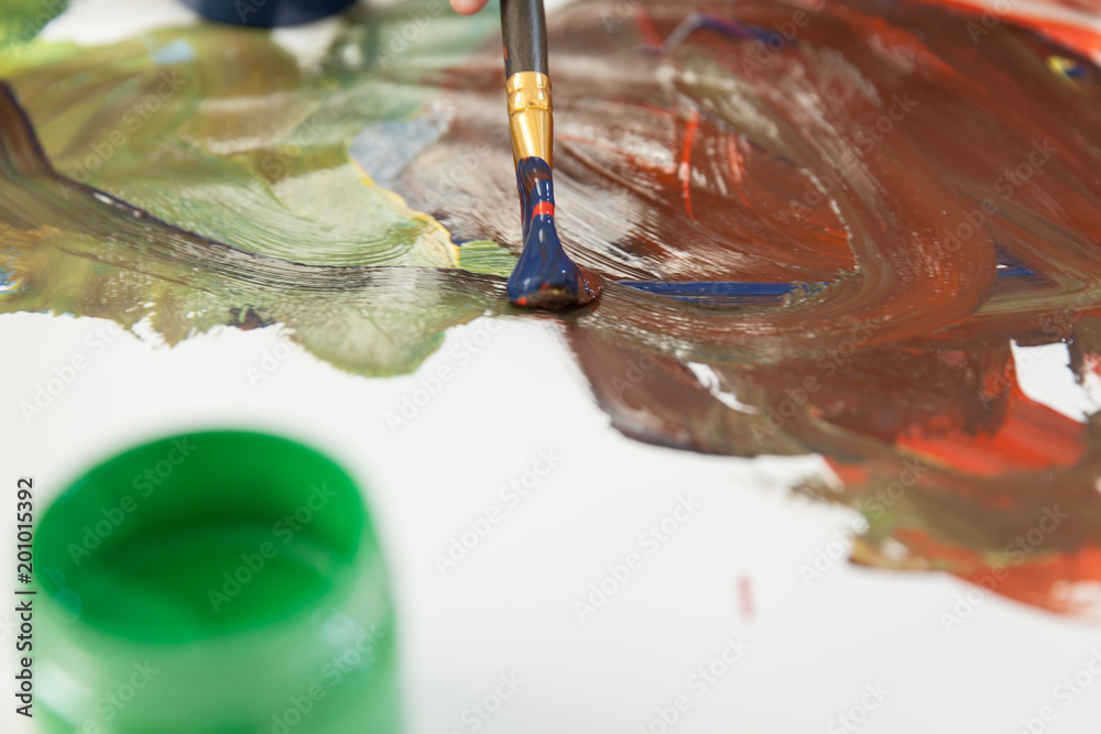 Obraz premium Green can with paint and mixing colors on paper.