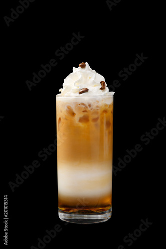 A multicolored, three-layered opaque cocktail in a tall glass with chopped ice, whipped cream and coffee beans, with a taste of coffee, caramel, cream and straw. Side view. Isolated black background