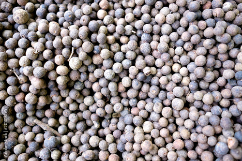 black aromatic peppercorns background, top view