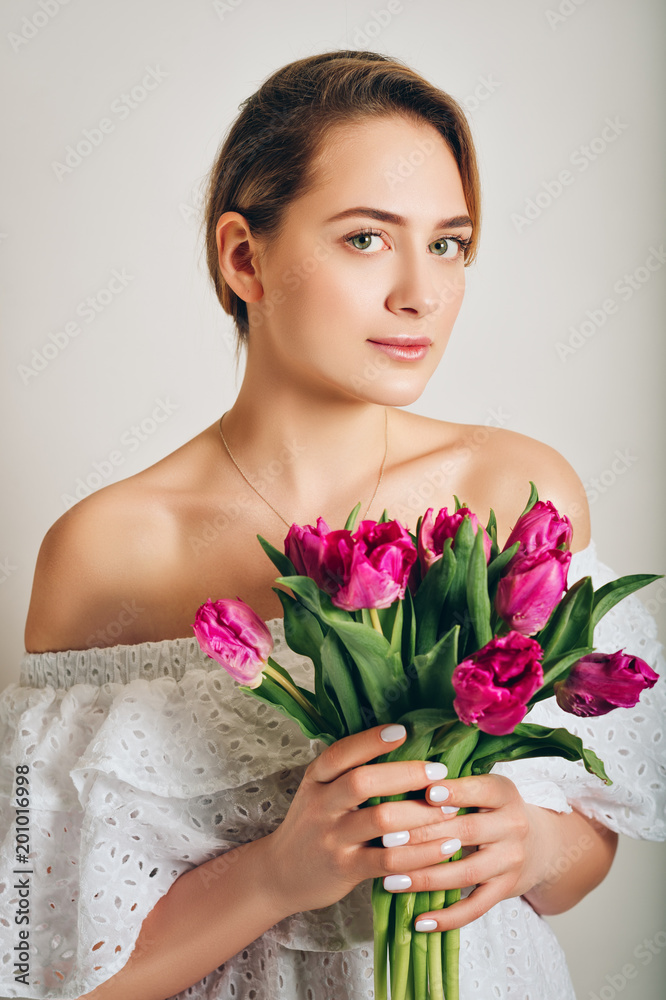 Studio shot of young beautiful girl holding purple tulip flowers Studio shot of young beautiful girl holding purple tulip flowers