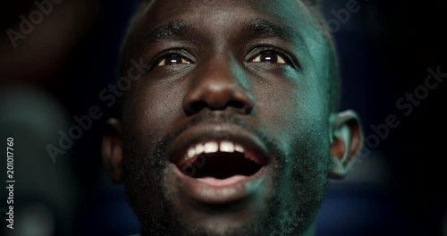 Young man at the cinema smiles before being awestruck. photo