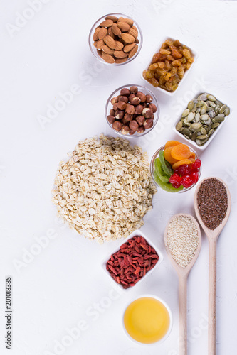 Ingredients for homemade oatmeal granola. Oat flakes, honey, nuts, dried fruit and seeds. Healthy breakfast concept.