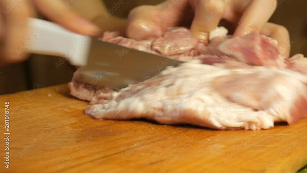 Woman cuts Meat with knife into small pieces on cutting board. Woman cuts Meat with knife into small pieces on cutting board.