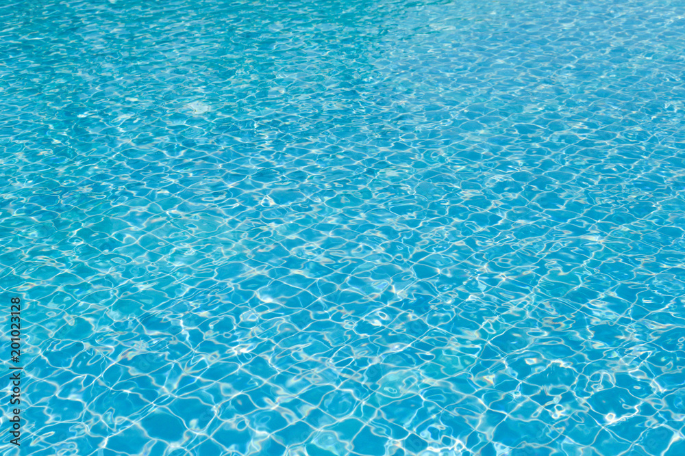 Bright water surface and ripple wave in swimming pool with blue tile