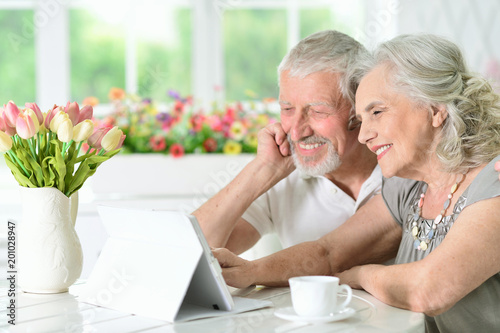 happy beautiful senior couple using tablet