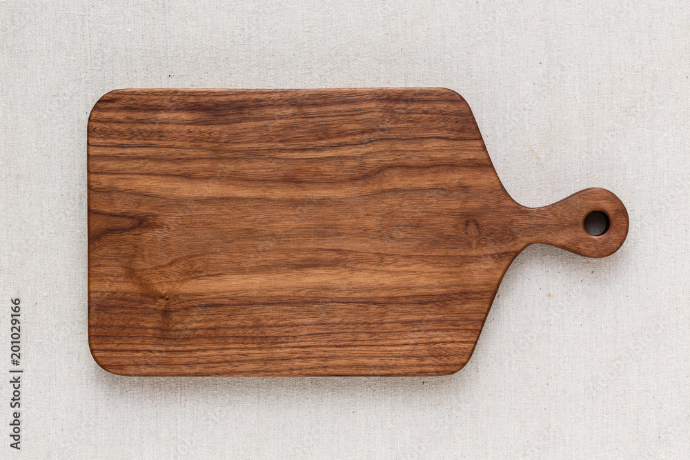 Walnut handmade wood cutting board on the linen - obrazy, fototapety, plakaty 