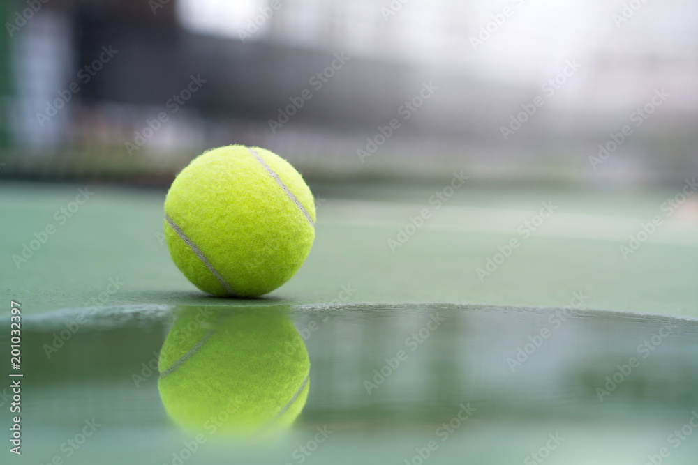 Reflection of tennis ball in water on the court background