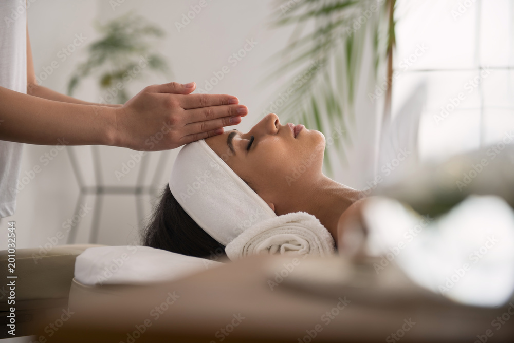 Professional spa massage. Peaceful calm woman closing her eyes and waiting  for the massage session to start Stock-Foto | Adobe Stock