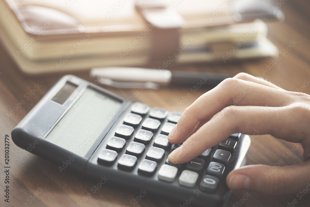 Hand using calculator on the table Hand using calculator on the table