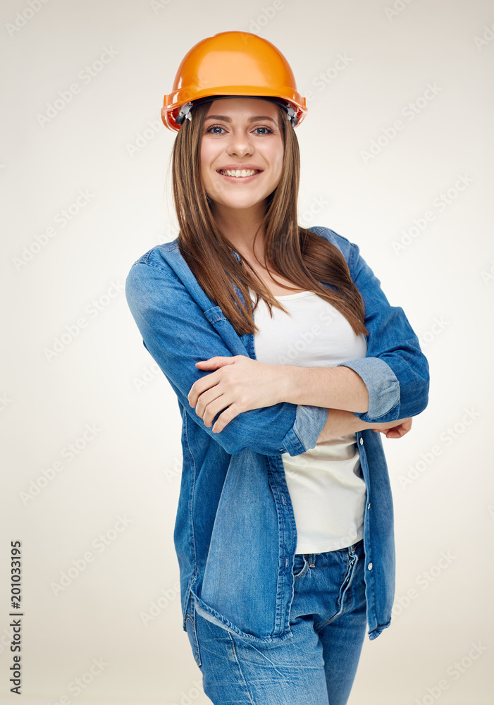 Smiling woman wearing builder helmet standing with crossed arms. Smiling woman wearing builder helmet standing with crossed arms.