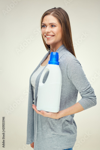 Housekeeper woman holding white bottle with cleanser or detergen photo