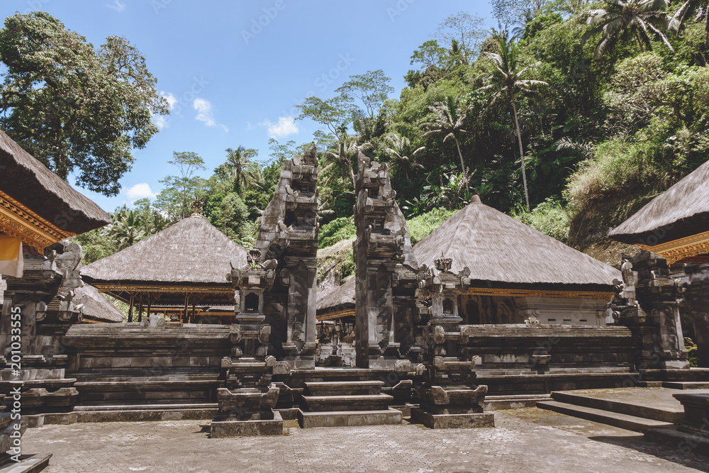 scenic view of ancient architecture of Temple Complex and Royal Tombs with blue sky and green plants around, Bali, Indonesia scenic view of ancient architecture of Temple Complex and Royal Tombs with blue sky and green plants around, Bali, Indonesia