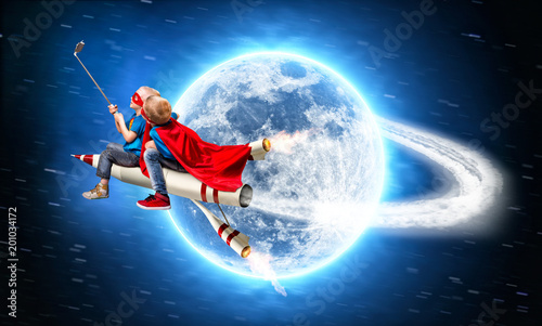 Children in superhero costumes fly in space on a rocket and shoot a selfie on a mobile phone.