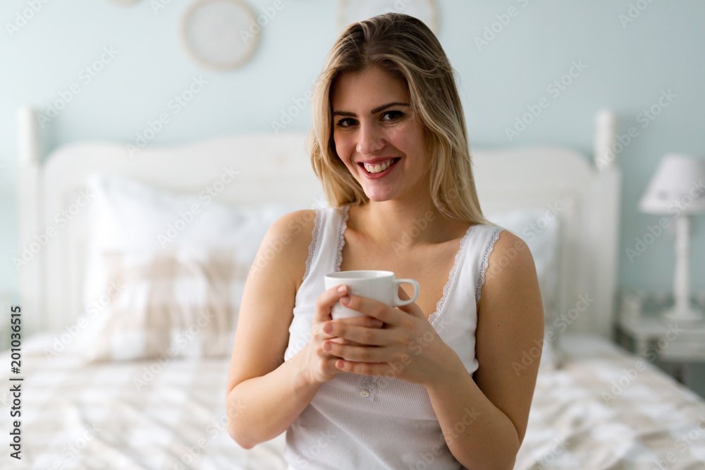 Young beautiful woman sitting on bed at home Young beautiful woman sitting on bed at home