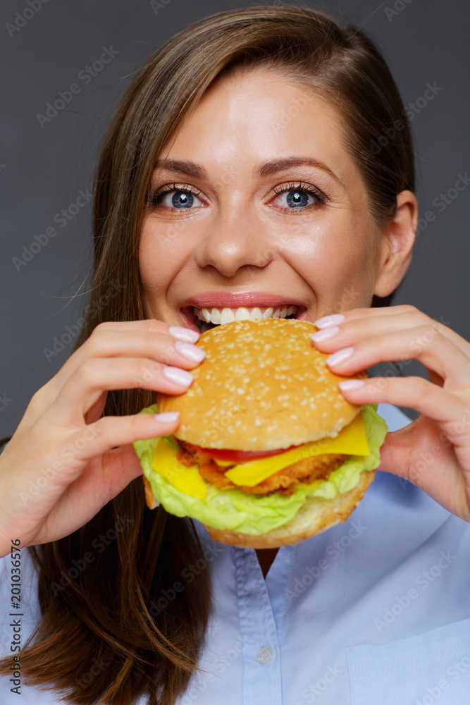 portrait of hungry woman eating burger. portrait of hungry woman eating burger.