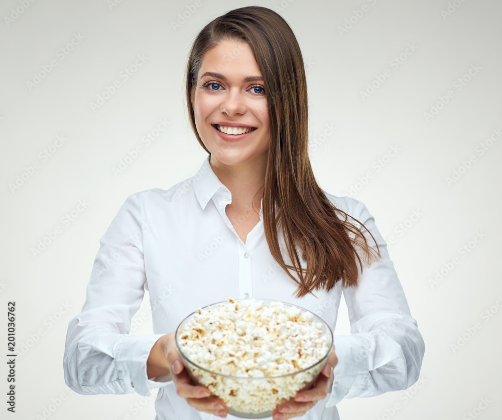 Smiling businesswoman holding big portion of pop corn in glass b Smiling businesswoman holding big portion of pop corn in glass b
