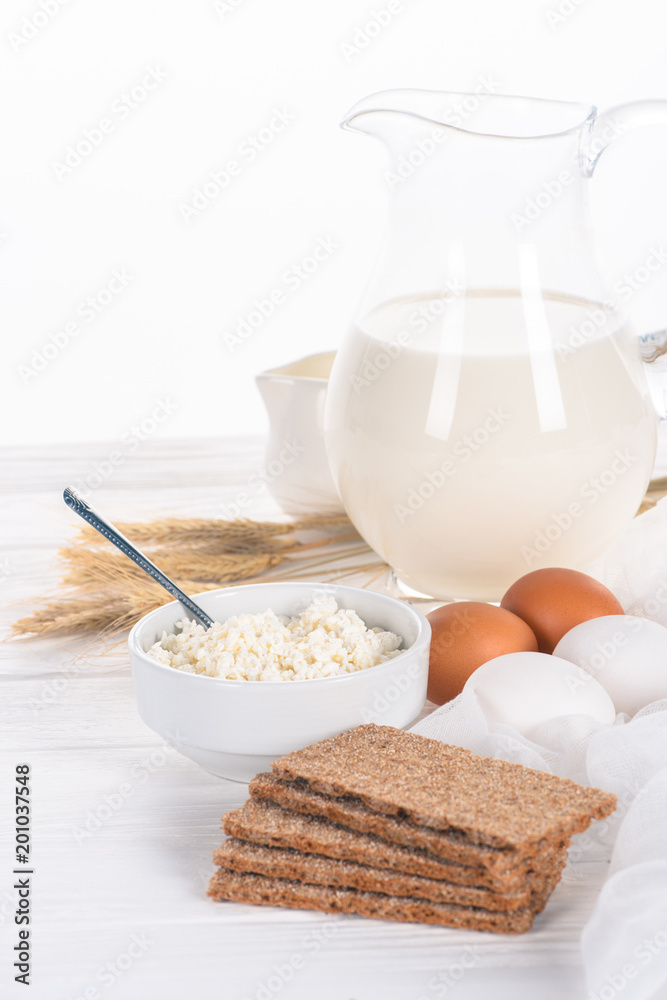 close-up view of crispy crackers, eggs, milk and cottage cheese on wooden table close-up view of crispy crackers, eggs, milk and cottage cheese on wooden table