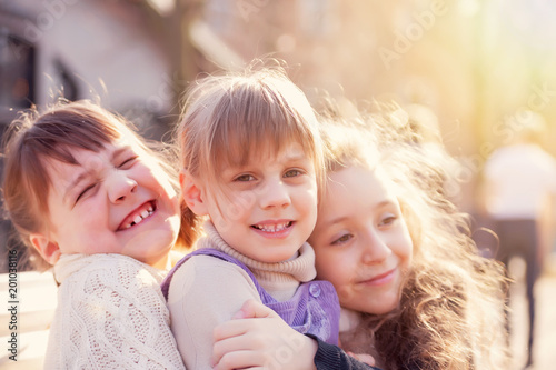  Three sisters sitting on bench in park.