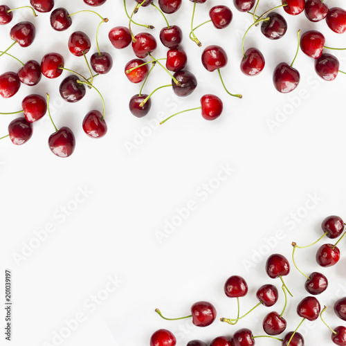 Fresh red cherries lay on white isolated background with copy space for text. Background of cherries. Ripe cherry on a white background. Top view. 
