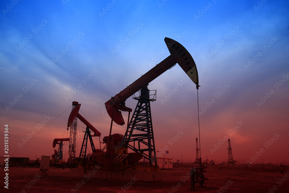 Pumping unit in the work, under the background of the setting sun Pumping unit in the work, under the background of the setting sun