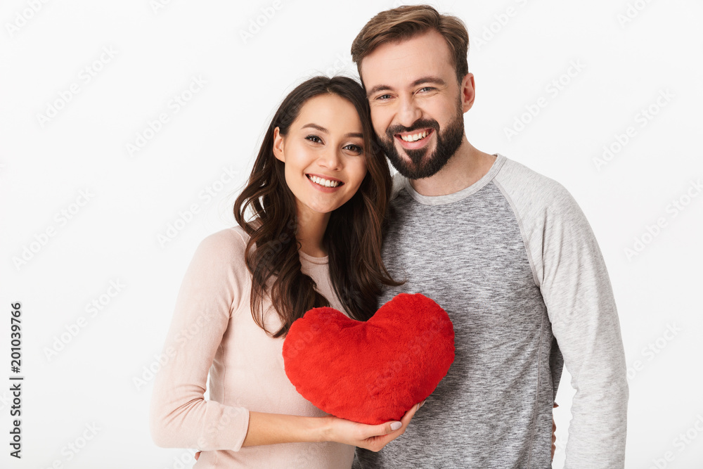 Happy young loving couple holding heart.