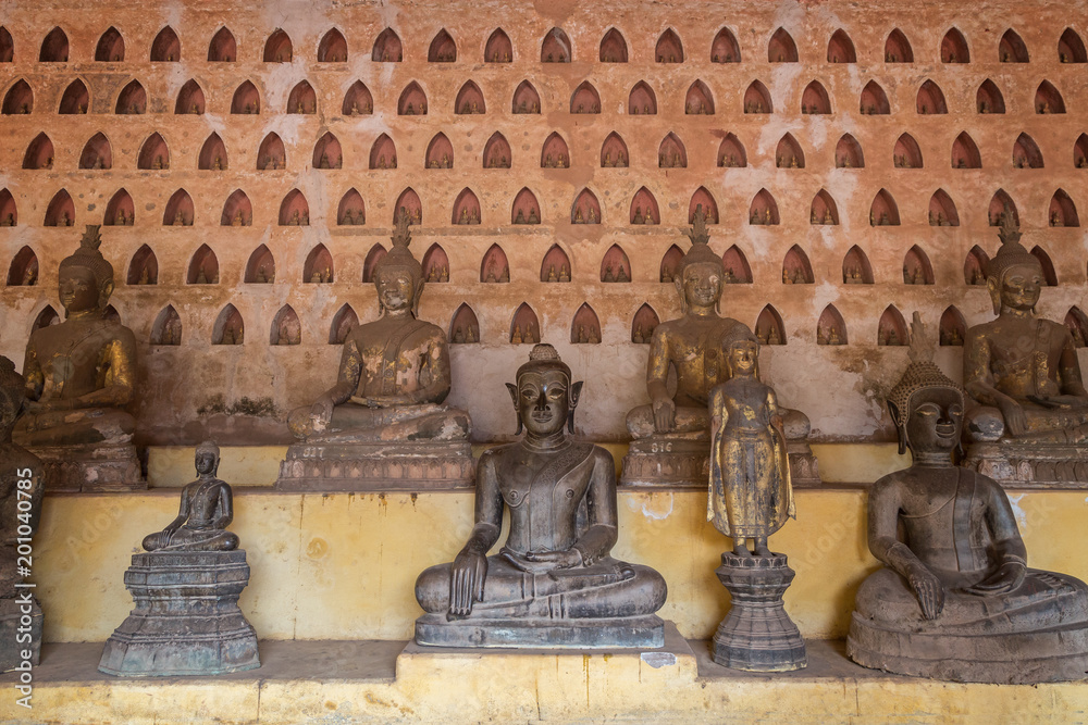 Front view of many old and aged Buddha statues at the Wat Si Saket (Sisaket) temple's cloister in Vientiane, Laos.