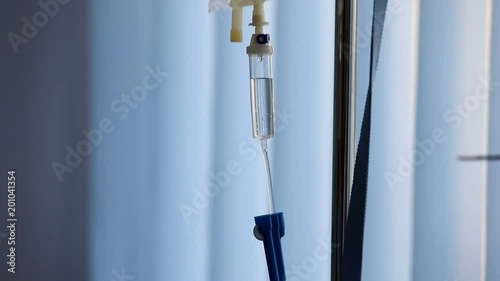close up of a slow intravenous drip with a blurred blue background
 photo
