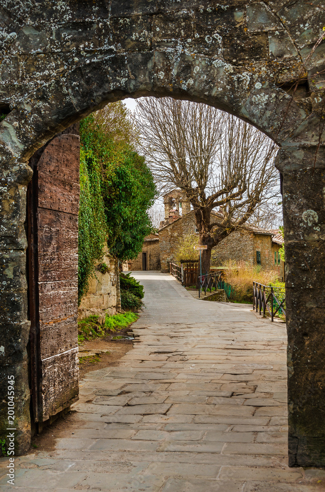 Cortona medieval historic center seen through Porta Montanina ancient gate, in Tuscany
