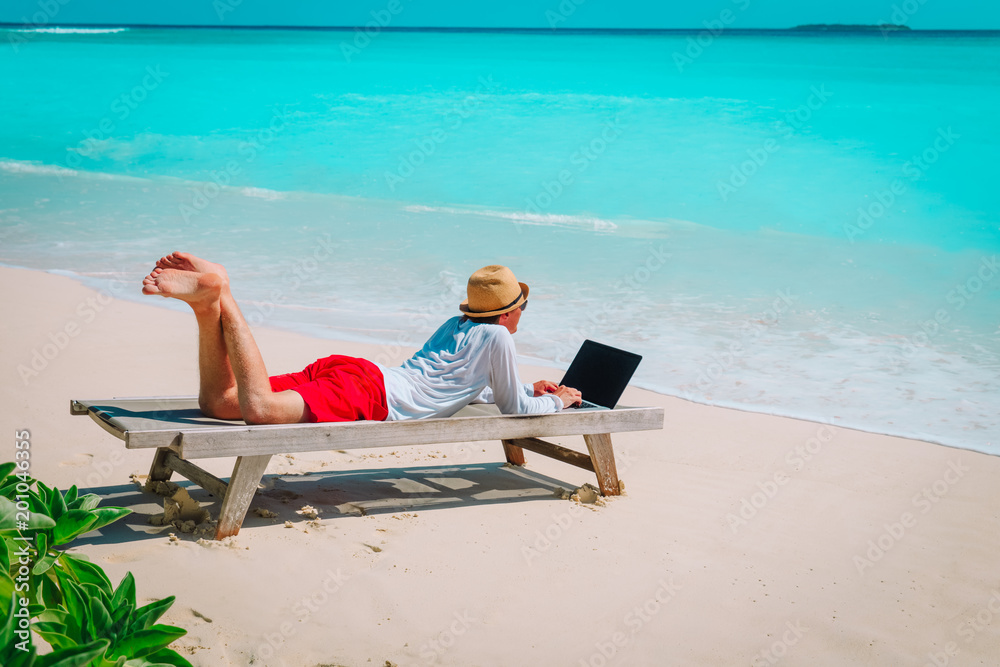 man with laptop on beach vacation, remote work concept