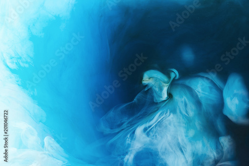 full frame image of mixing of blue, black and white paints splashes in water