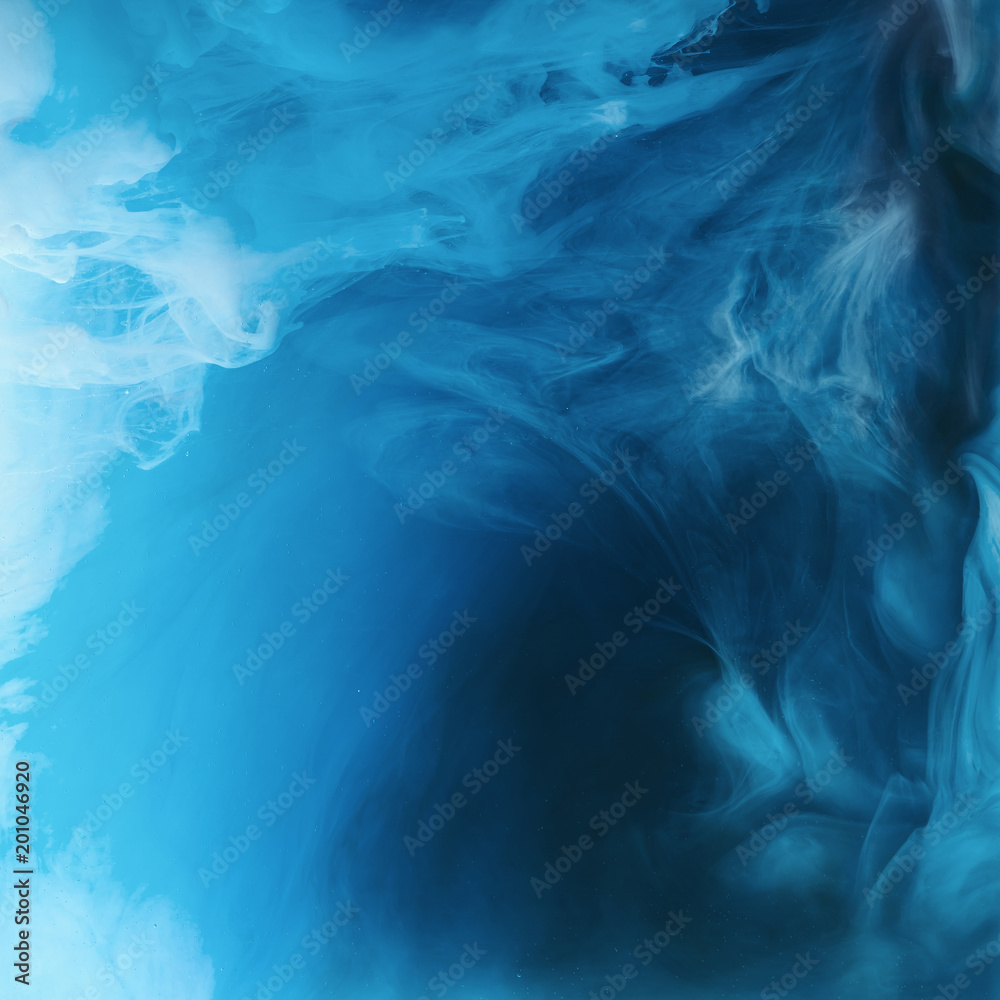 Obraz premium full frame image of mixing of blue, black and white paints splashes in water