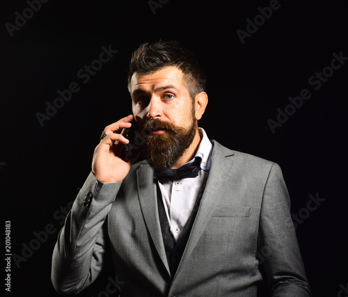 Business and appointment concept. Man with long beard holds phone