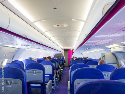 Interior of passenger airplane with people on seats