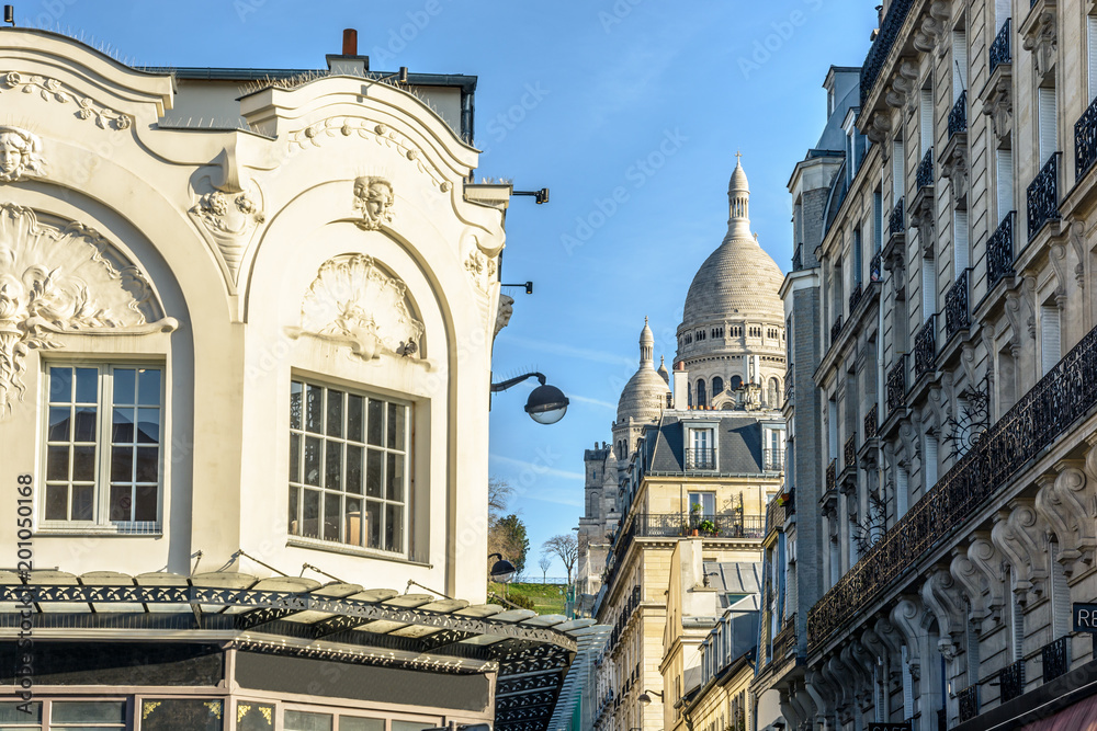 Φωτογραφία View of the facade and dome of the Basilica of the Sacred Heart of Paris through a narrow street between old parisian buildings under a clear blue sky