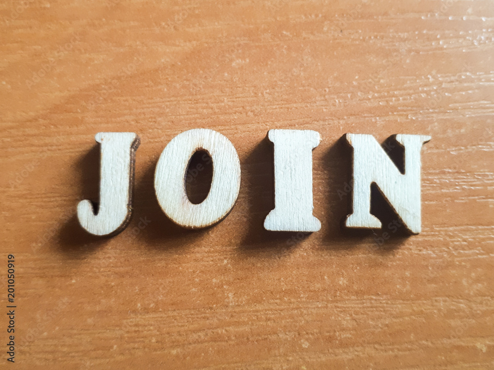 The word 'join' made of wooden letters. wood inscription on a keyboard background