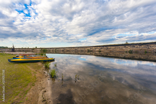 collection of colorful kayaks on riverside at summer day