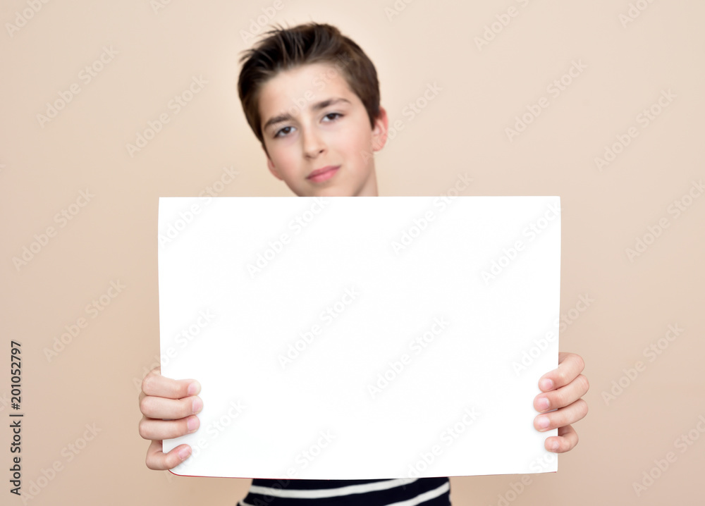 Young boy holding a blank white board. Focus on the white board. Young boy holding a blank white board. Focus on the white board.