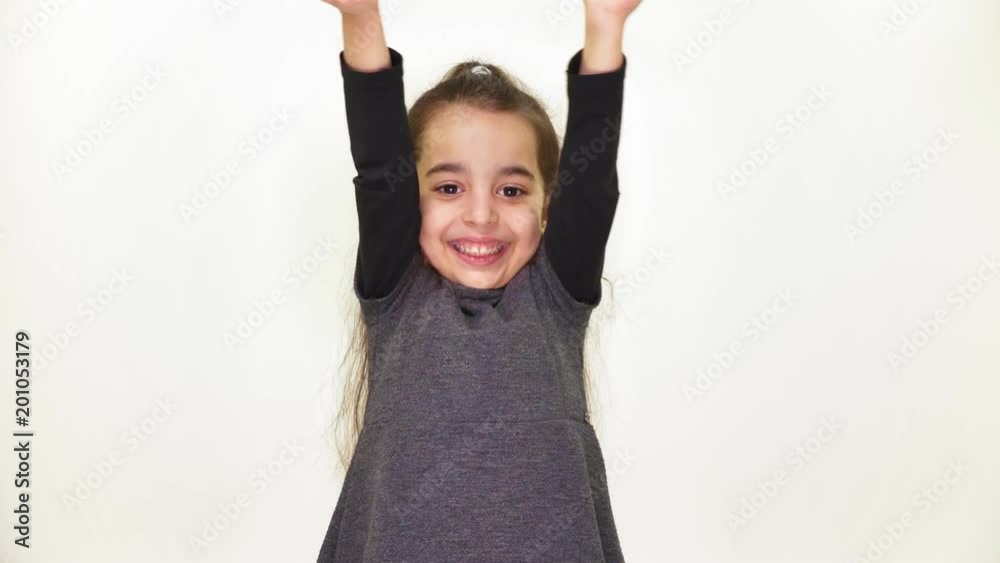 Little beautiful sweet girl is happy, smiling, rejoicing, raises her arms to the top, surprised, white background, white background 50 fps Little beautiful sweet girl is happy, smiling, rejoicing, raises her arms to the top, surprised, white background, white background 50 fps